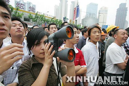 市民在用望远镜观看阿兰·罗伯特攀爬金茂大厦
